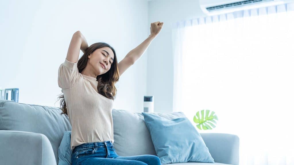 Picture of a woman enjoying her ac after having seasonal HVAC maintenance in Ocala.