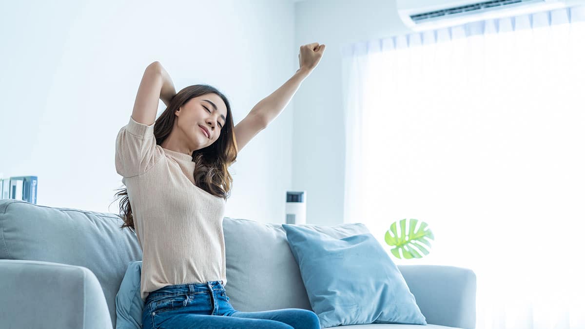 Picture of a woman enjoying her ac after having seasonal HVAC maintenance in Ocala.