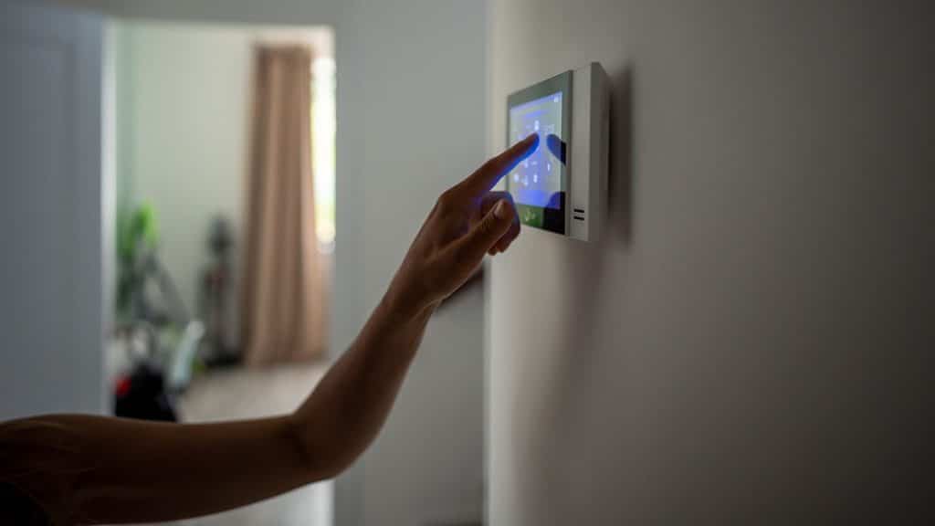 Closeup hand using smart thermostat in ocala home