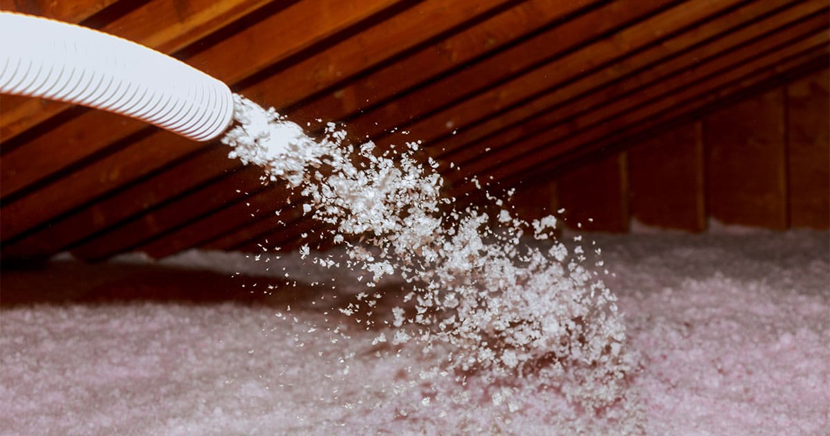 Spraying fiberglass insulation into attic in Ocala FL