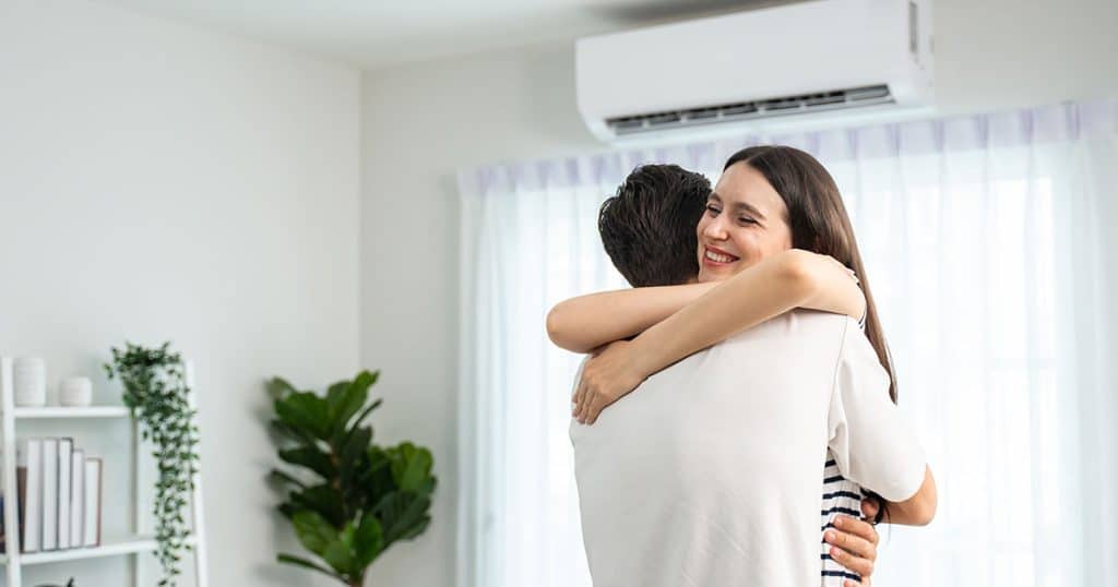 A joyful woman smiles while embracing a person in a brightly lit, modern Ocala home