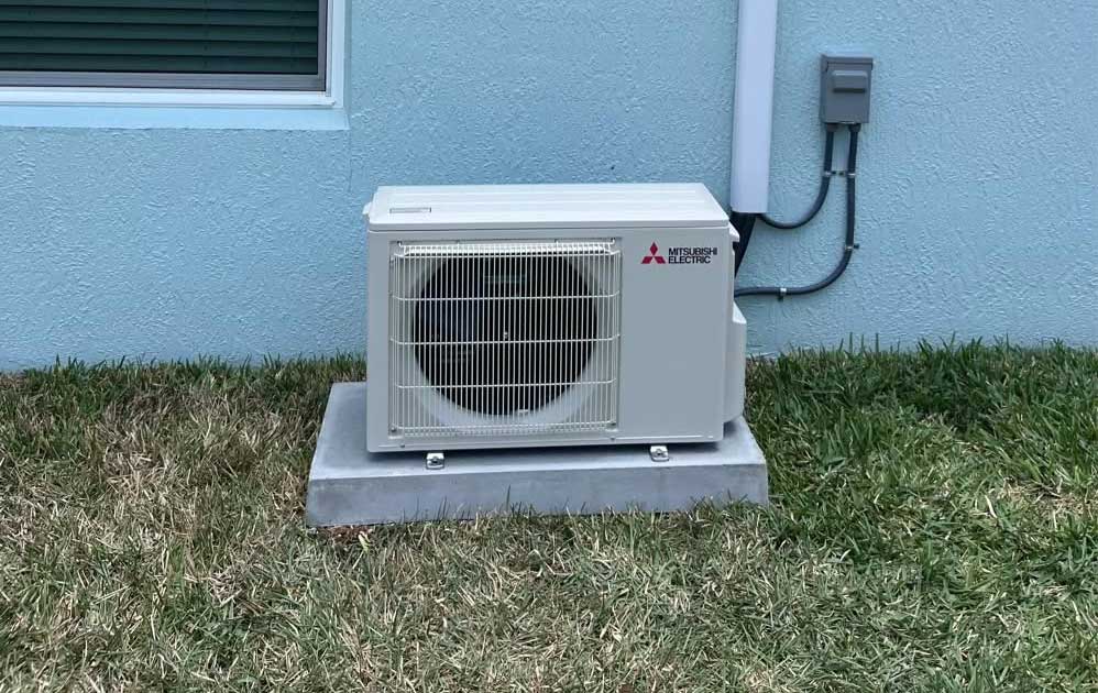 Mitsubishi Electric outdoor AC unit installation on a concrete pad by ABS Heating & Air in Ocala, FL