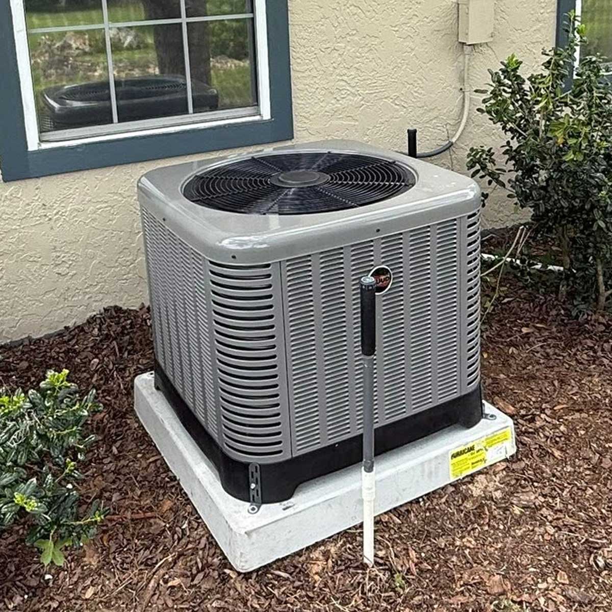 Residential outdoor AC condenser unit receiving preventative maintenance in Ocala FL